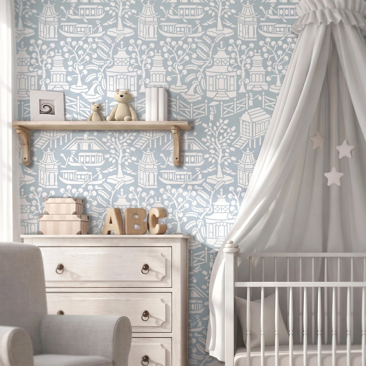 Asian garden wall stencil  in a styled nursery room  with a white wooden dresser, a white crib with a white canopy decorated with stars, and a light gray patterned rug, and natural light highlighting the blue and white painted stencil on the wall.