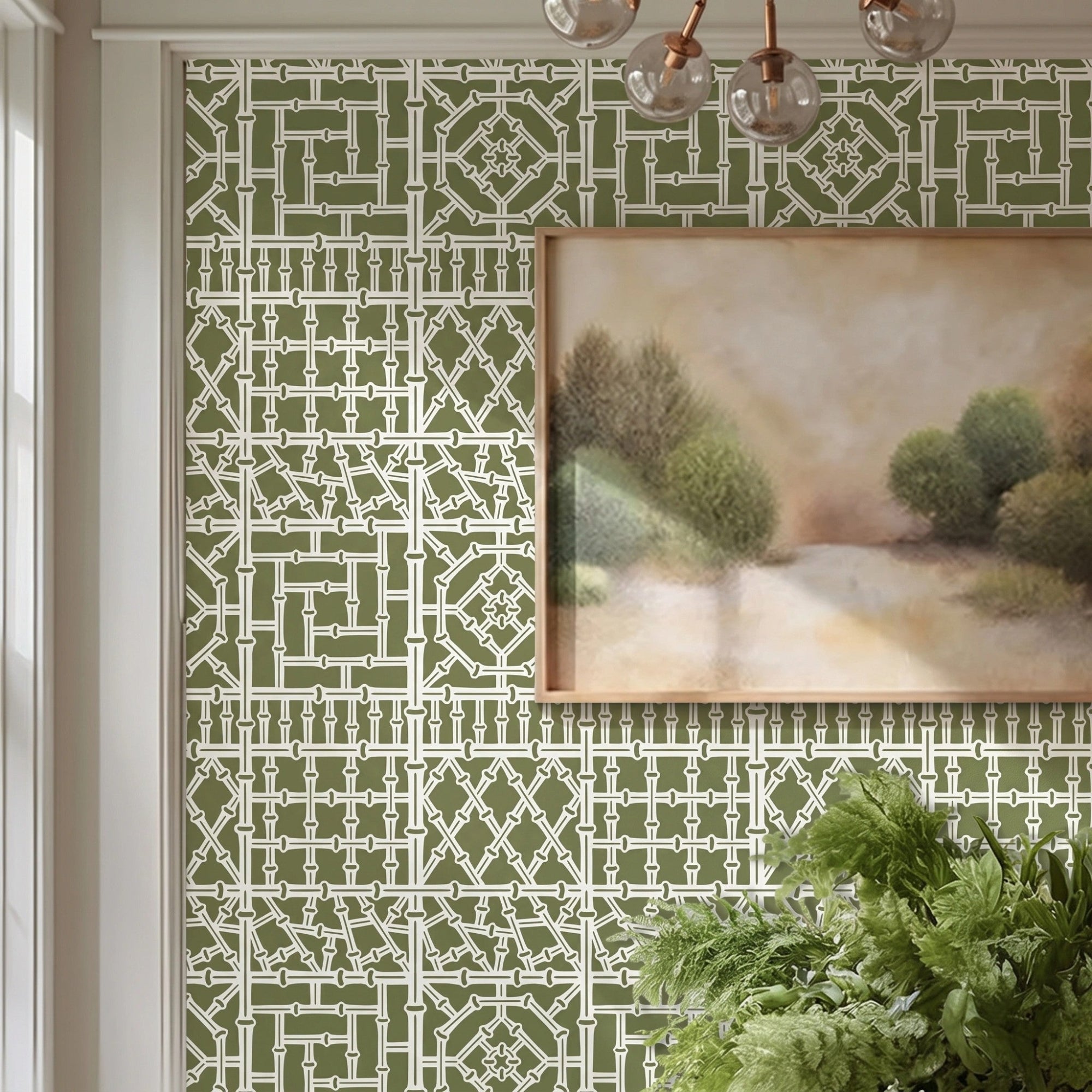 Bamboo wall stencil in a dining room, styled with a framed landscape painting and a green plant, and natural light highlighting the green and white painted stencil on the wall.