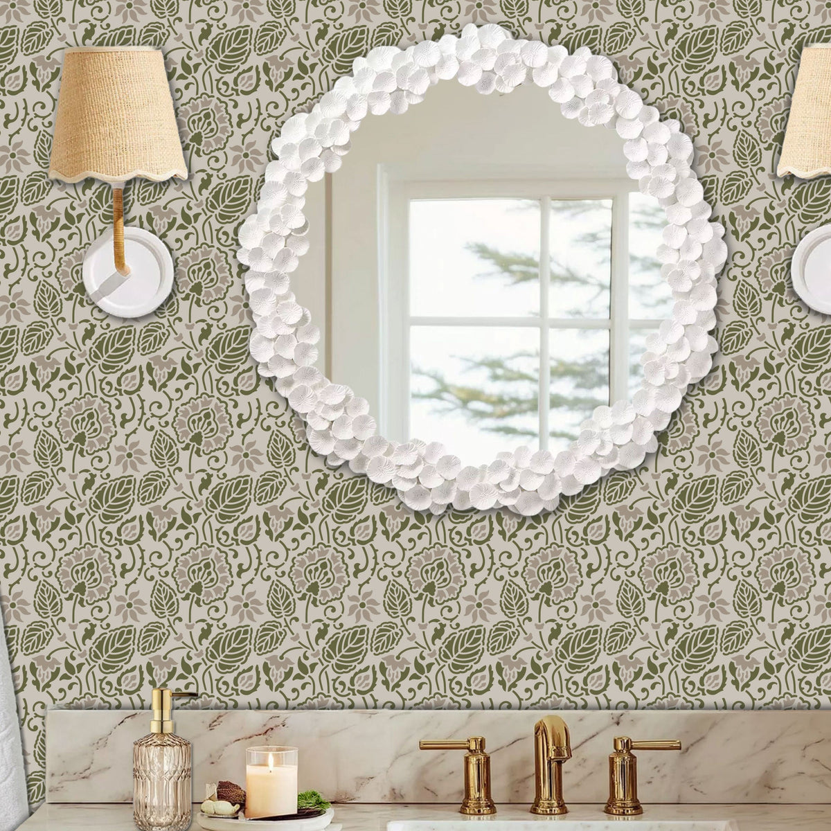 Dandelion wall stencil in a powder room with a round wall mirror, with wall sconces, and a marble sink with brass fixtures, with natural light highlighting the olive green and soft taupe painted stencil on the wall.