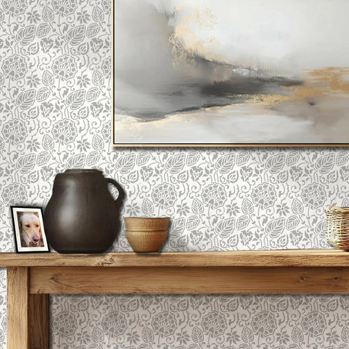 Dandelion wall stencil featured in a hallway with a wooden console table, a dark ceramic pitcher, a small woven bowl, and a framed abstract painting on the wall, with natural light highlighting the gray and white stencil painted on the wall.