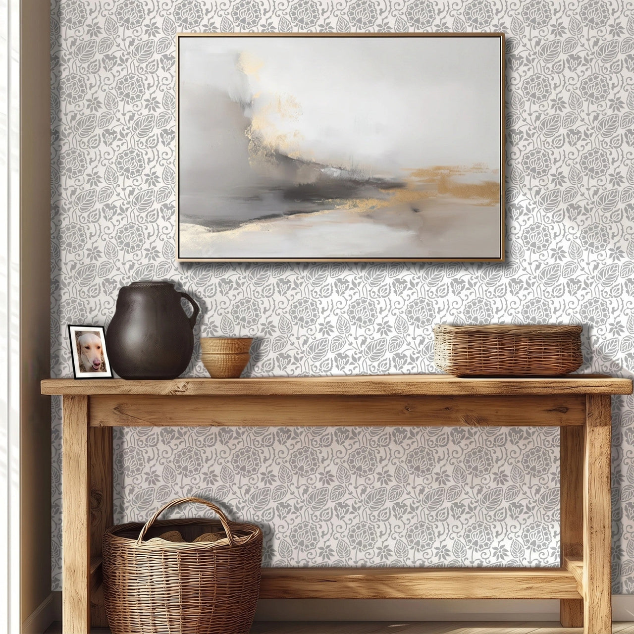 Dandelion wall stencil featured in a hallway with a wooden console table, a dark ceramic pitcher, a small woven bowl, and a framed abstract painting on the wall, with natural light highlighting the gray and white stencil painted on the wall.