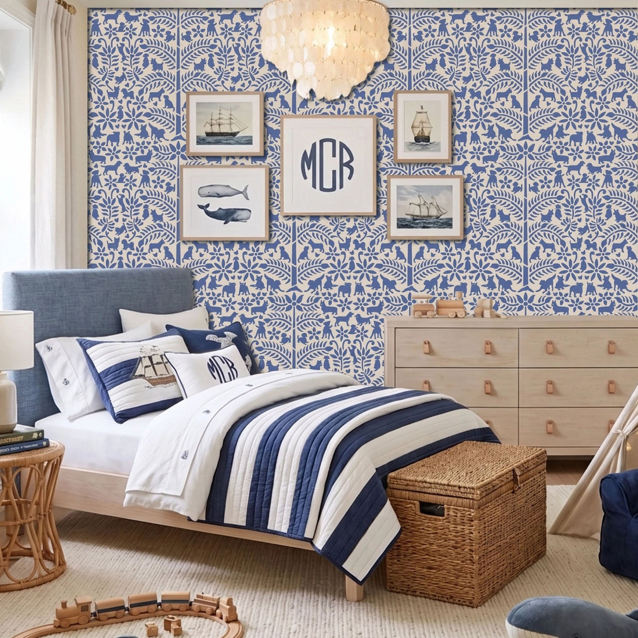 Dogs in the garden wall stencil applied in a children's bedroom featuring a bed with navy and white striped bedding, framed prints, a wood dresser, and a chandelier, and natural light highlighting the dark blue and beige painted stencil on the wall.