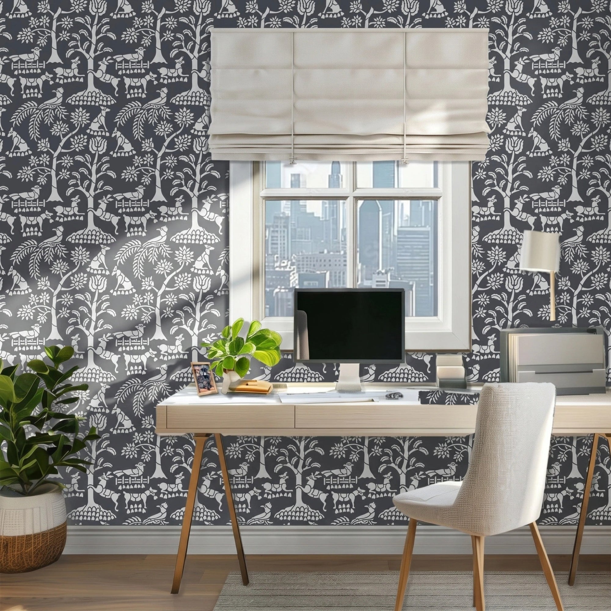 Enchanted forest wall stencil  featured in an office with a window and a beige roman shade, a desk with a computer monitor, plants, a chair, and natural light highlighting the charcoal and light grey painted stencil on the wall.