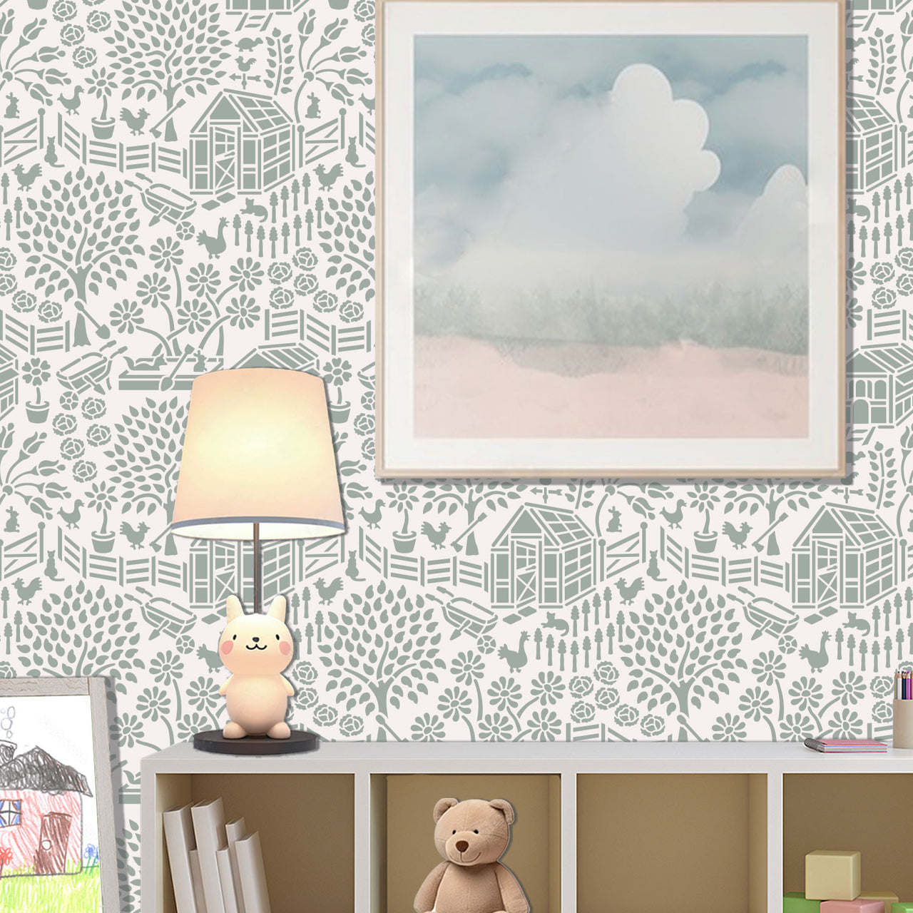 Floral garden stencil applied on the wall with a framed landscape print, a lit table lamp shaped like a rabbit, and a shelf with books and a teddy bear, and soft natural light highlighting the soft green and white painted stencil on the wall.
