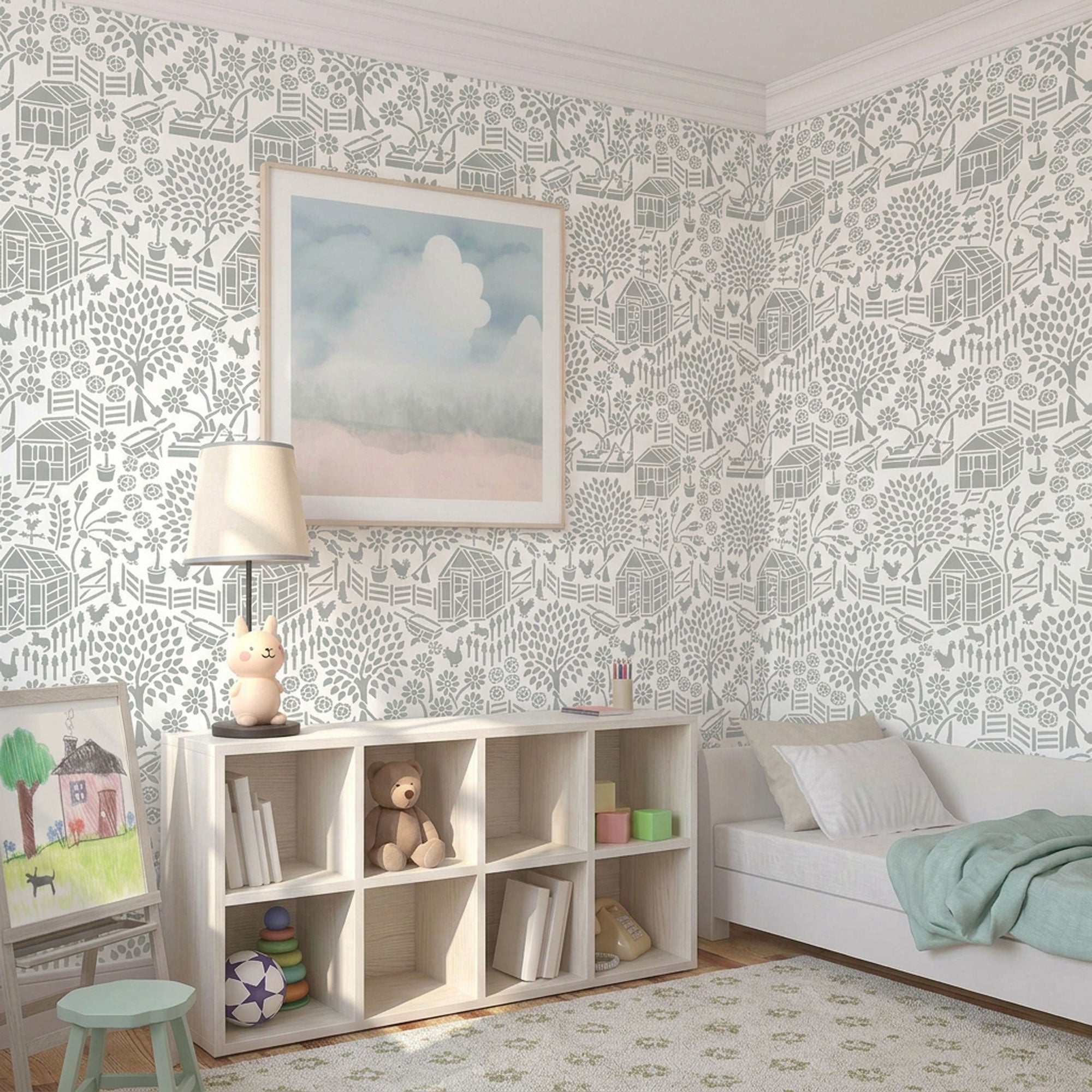 Floral garden stencil applied on the wall with a framed landscape print, a lit table lamp shaped like a rabbit, and a shelf with books and a teddy bear, and soft natural light highlighting the soft green and white painted stencil on the wall.