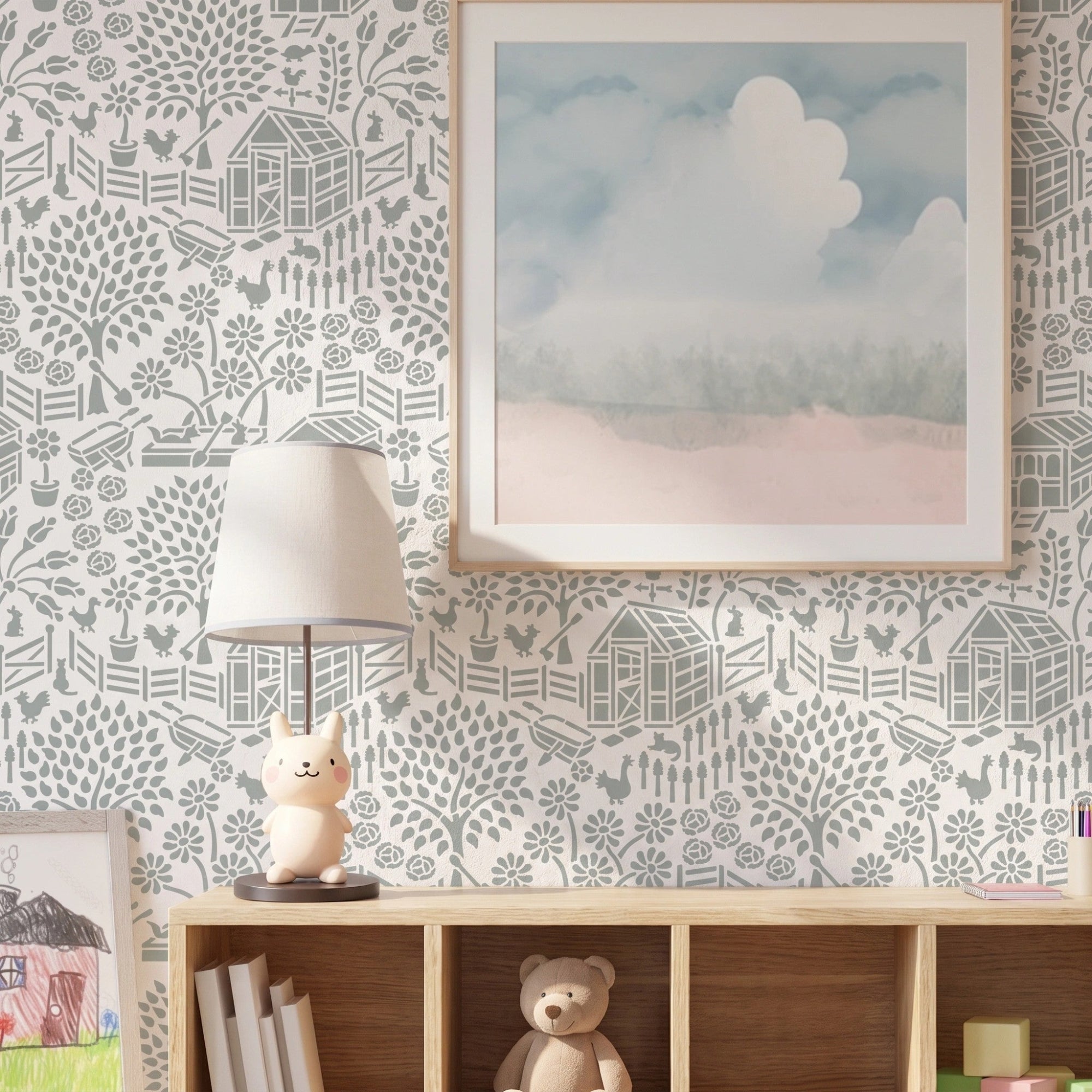 Floral garden wall stencil applied on the wall with a framed landscape print, a lit table lamp shaped like a rabbit, and a shelf with books and a teddy bear, and soft natural light highlighting the soft green and white painted stencil on the wall.
