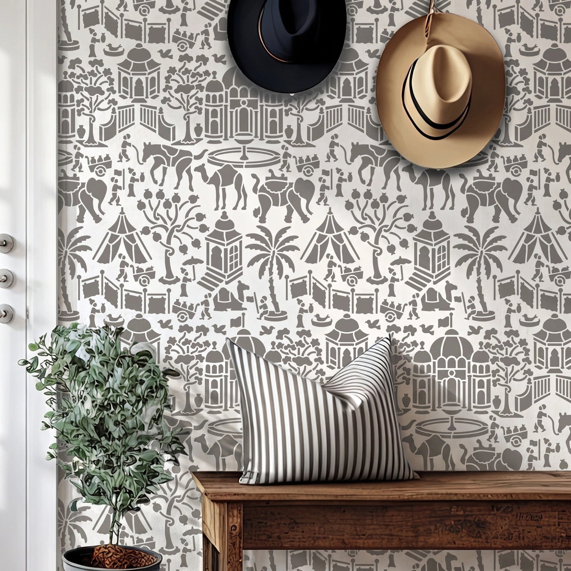 Indian village wall stencil applied in a entryway featuring a wooden bench, two hats hanging on the wall, a plant, a front door, and natural light highlighting the gray and white wall stencil painted on the wall.