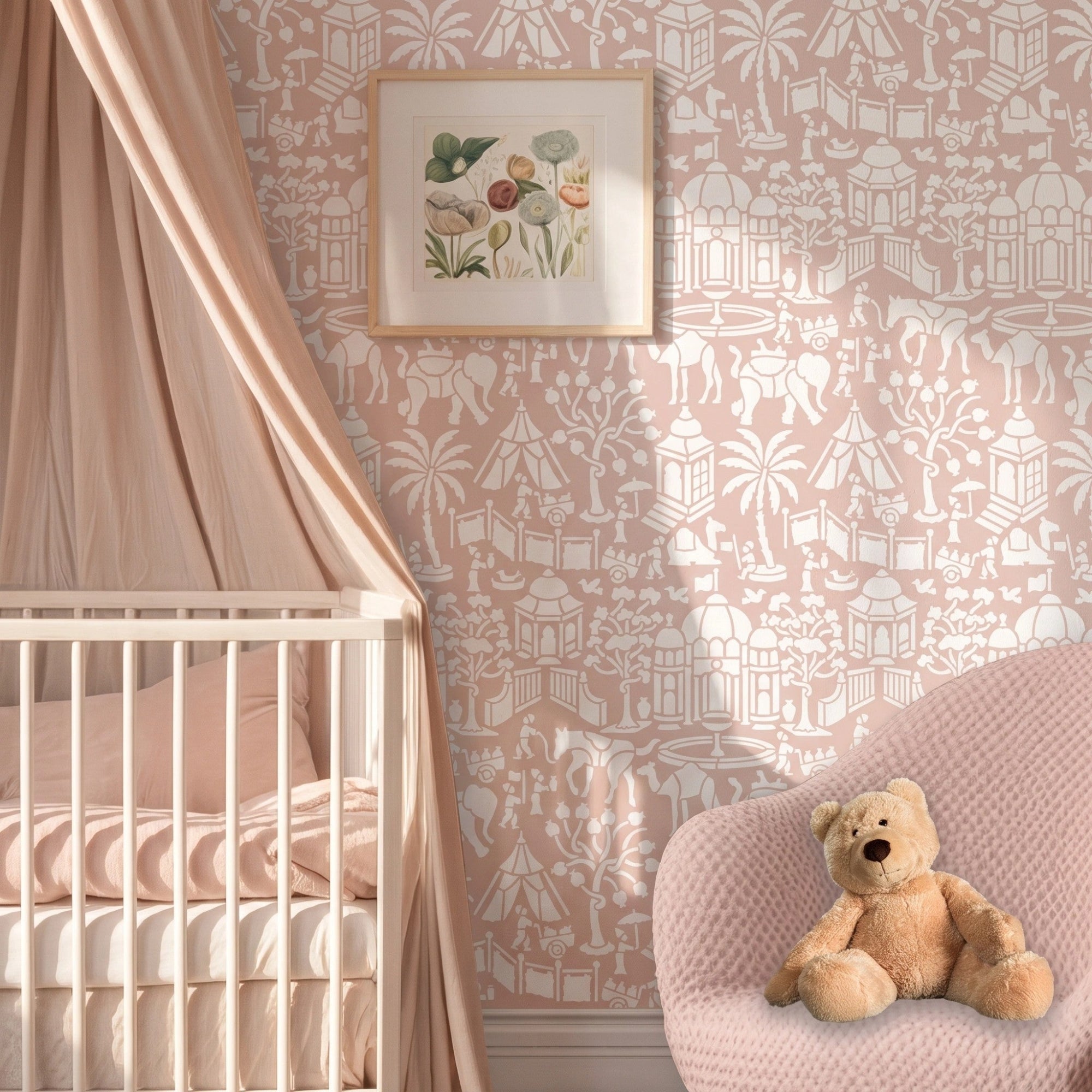 Indian village wall stencil applied in a nursery featuring a crib with a canopy, a teddy on a pink chair, a small floral painting on the wall, and natural light highlighting the pink and white painted stencil on the wall.
