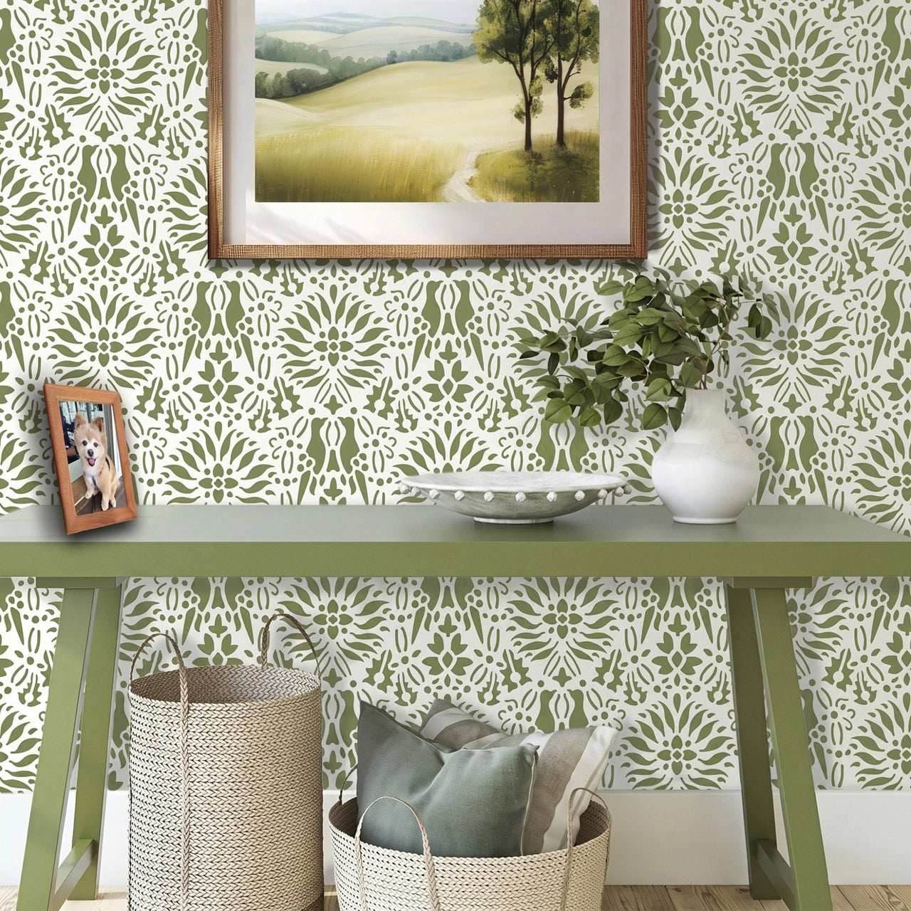 Morning dove wall stencil applied in a styled room setting with a green console table, a framed landscape print, a white vase with greenery, and woven baskets, and soft natural light highlighting the green and white painted stencil on the wall.