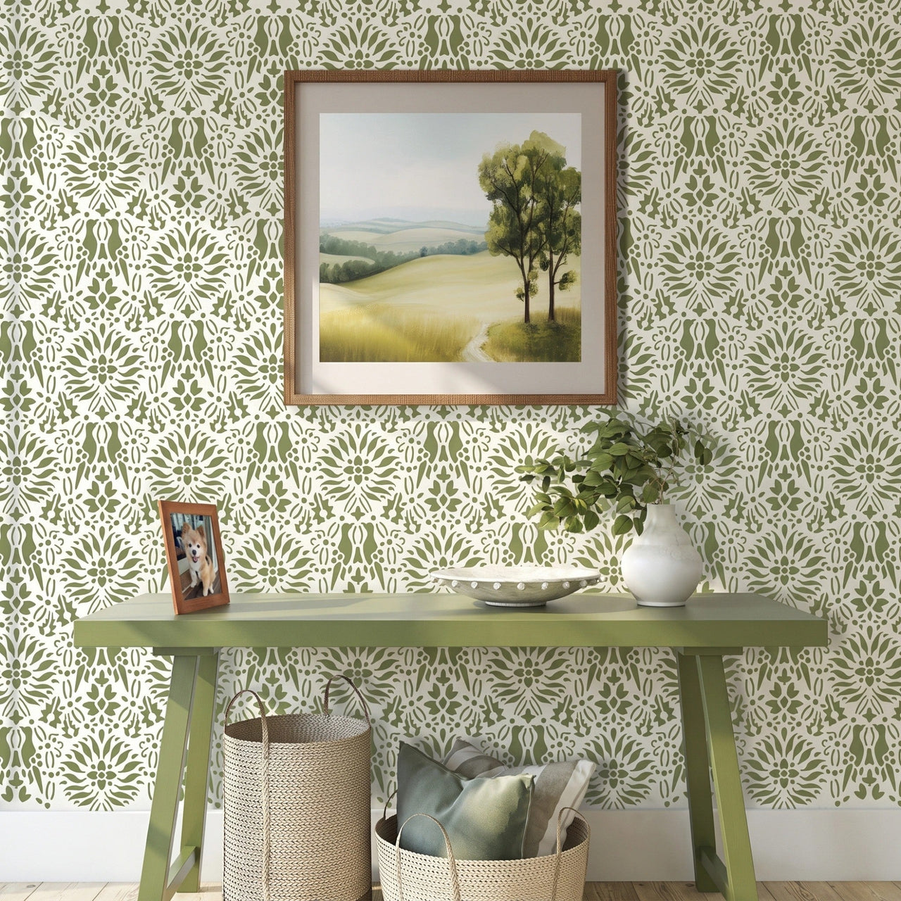 Morning dove wall stencil applied in a styled room setting with a green console table, a framed landscape print, a white vase with greenery, and woven baskets, and soft natural light highlighting the green and white painted stencil on the wall.