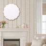 Moroccan lattice wall stencil applied behind a white fireplace mantel with tulips, books, a scalloped mirror, and soft natural light creating a warm, elegant room setting.
