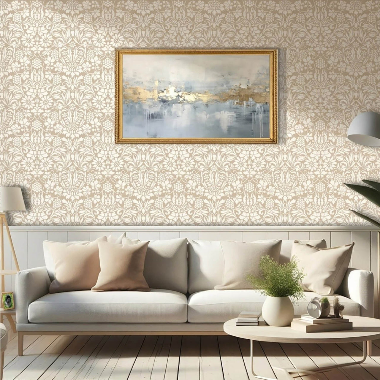 Thistle and Vine wall stencil pattern applied in a living room setting with beige pillows, chair rail molding and a painting with a gold frame, and natural light highlighting the beige and cream painted stencil on the wall.