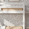 Woodland Foxes wall stencil applied behind a white bunk bed, featuring an all-over woodland pattern with foxes, flowers, leaves, and branches, and natural highlight the dark green and light green painted stencil on the wall.