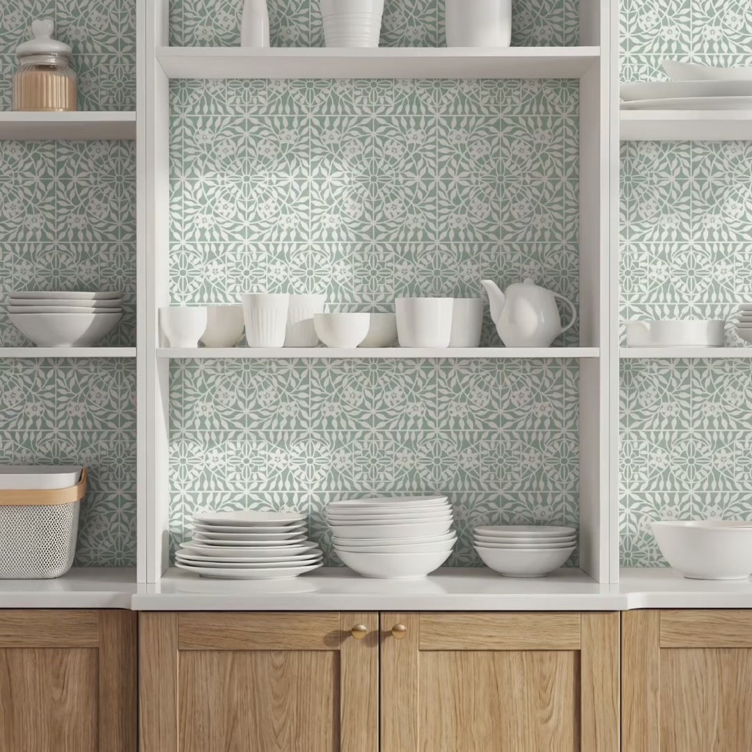 Woman enters the room that has the botanical tile wall stencil painted inside the cupboard. She picks up some plates from the cupboard and exits the room.