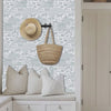 Woman enters through the door into her mudroom with Day at the Farm Farmhouse stencil painted on the walls.