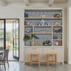 Spear thistle wall stencil painted behind built in bar. Man, woman and dog enter the room from the garden and pull out the bar stools video.