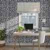 Enchanted forest wall stencil in office. Woman walks in and sits in the chair and pick up her cell phone