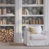 Damask Block Print wall stencil in library.Man enters carrying fireplace wood followed by a husky dog, then he sits in the chair and looks at his phone video.